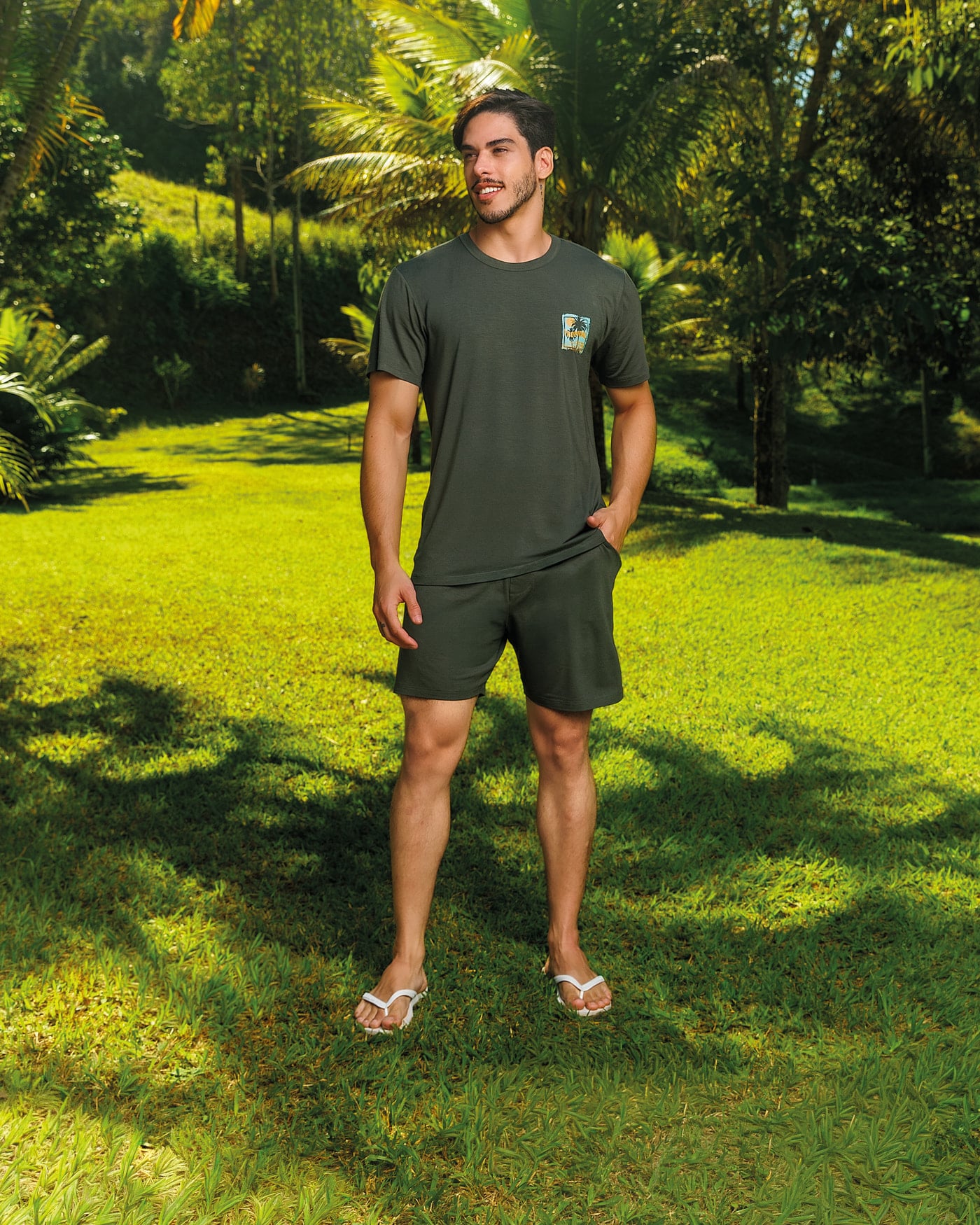 Homem de pijama verde-oliva em pé no gramado