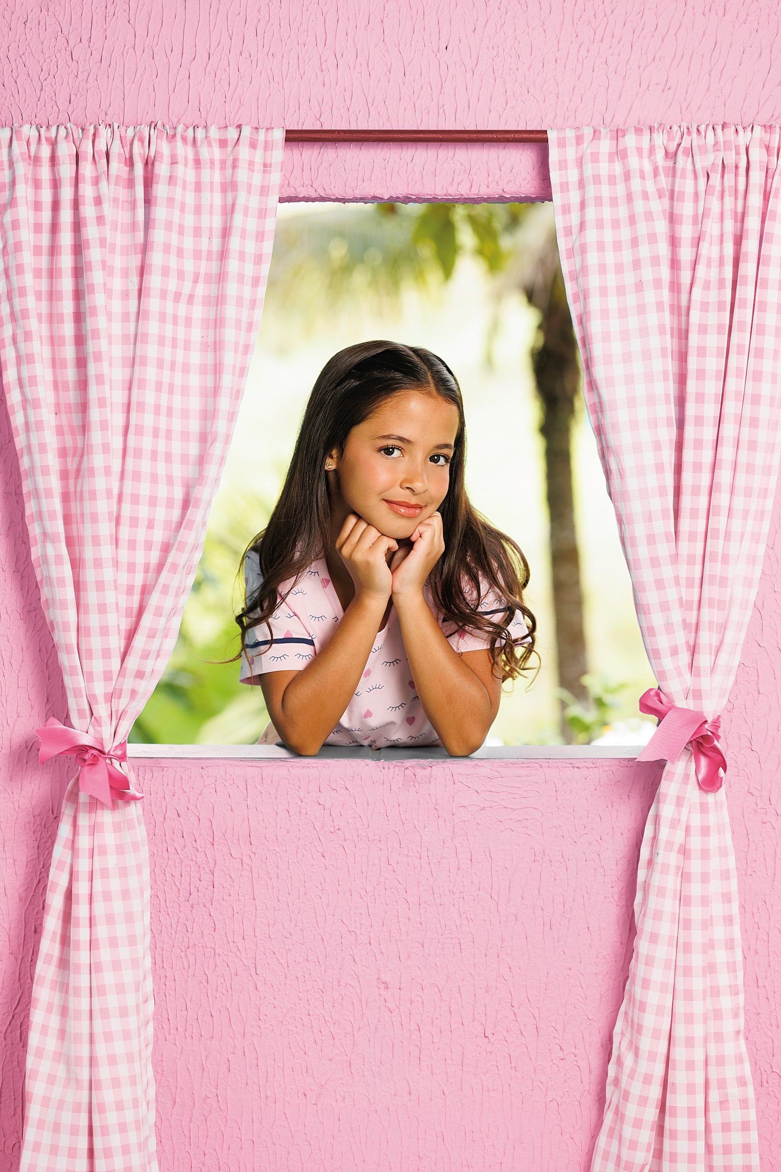 Menina de pijama rosa sorrindo na janela, coleção Encantos