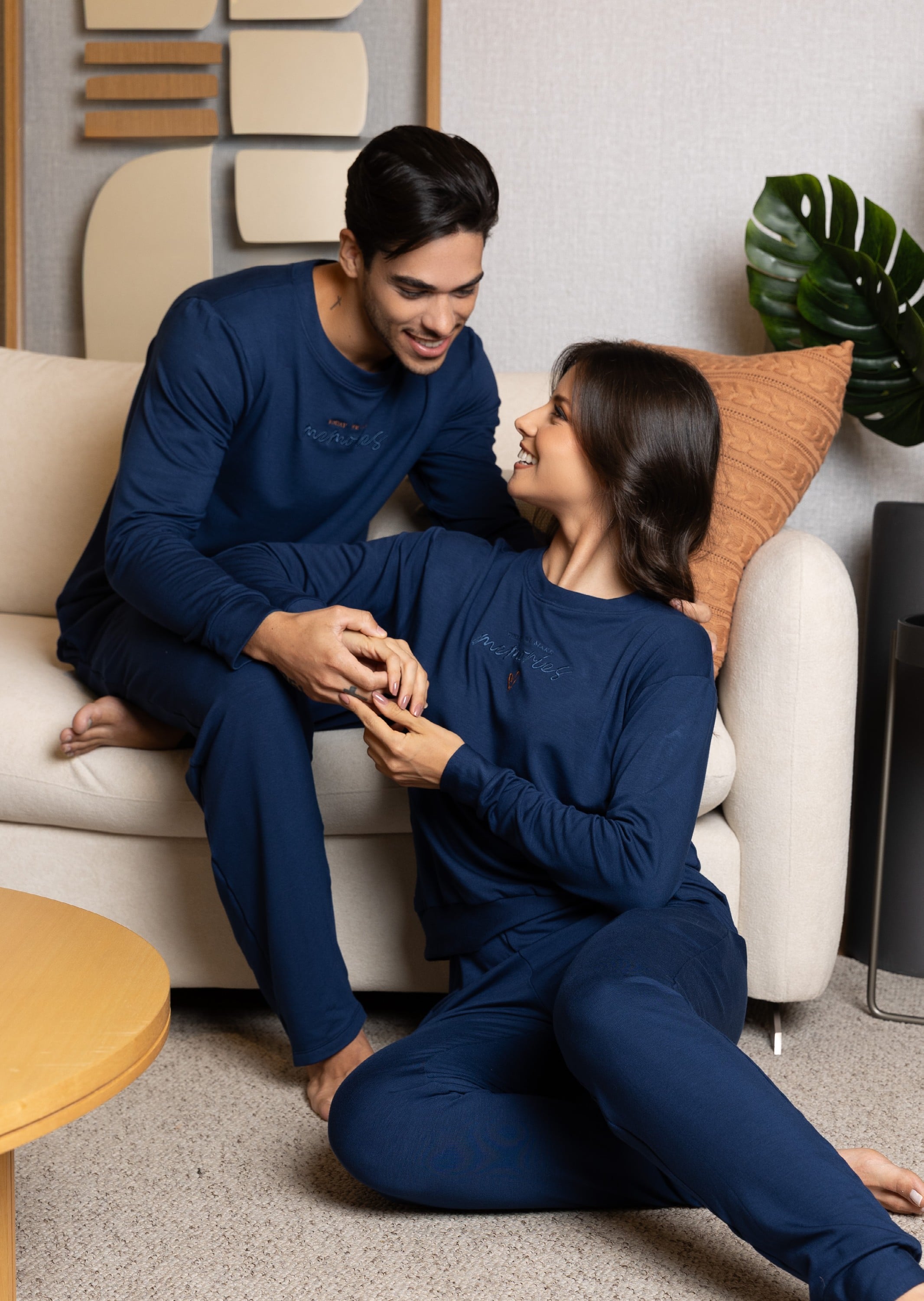 Casal de pijamas azul-marinho na sala, coleção Sintonia